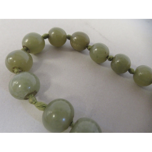 104 - An antique Chinese green jade, turned, graduated bead necklace, on a toggle clasp  18