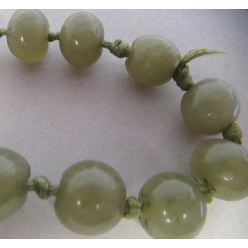 104 - An antique Chinese green jade, turned, graduated bead necklace, on a toggle clasp  18