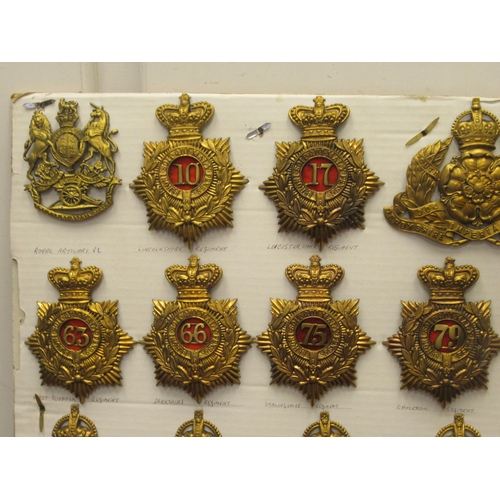 105 - Approx. thirty military helmet plates and other insignia, some copies: to include Northumberland Fus... 