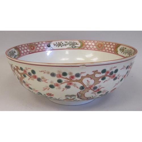 114 - A late 19thC Chinese porcelain footed bowl, decorated with flowering prunus, flora in reserves and h... 