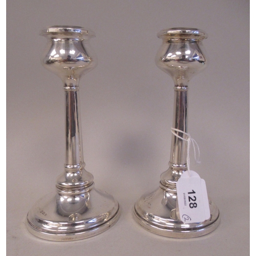 128 - A pair of Art Nouveau inspired loaded silver candlesticks, each with a tulip design socket and a tap... 