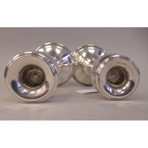 128 - A pair of Art Nouveau inspired loaded silver candlesticks, each with a tulip design socket and a tap... 