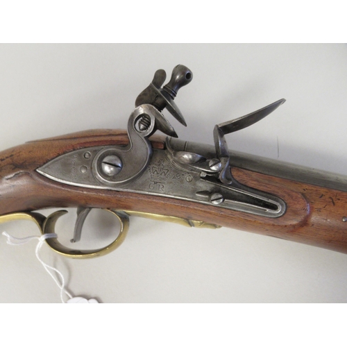 160 - A late 18thC design Tower flintlock pistol with a walnut stock, an applied brass butt, trigger guard... 