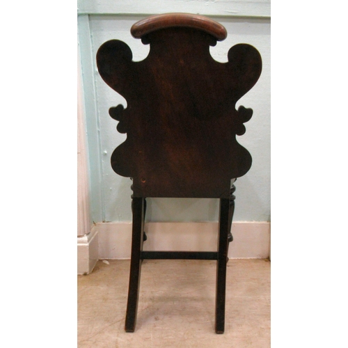 181 - A mid 19thC mahogany hall chair, the boldly, scroll carved, one piece back over a hollow seat, raise... 