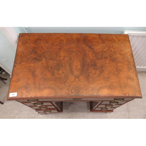 186 - A 19thC figured veneer walnut kneehole desk, over a shallow frieze drawer, flanked by six short draw... 