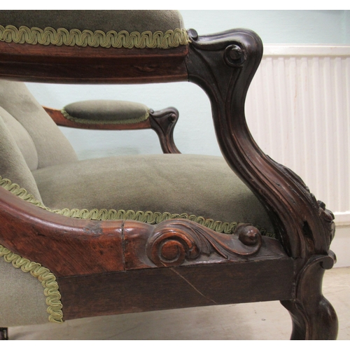 187 - An early Victorian carved showwood framed rosewood library chair with a scrolled back and open arms,... 