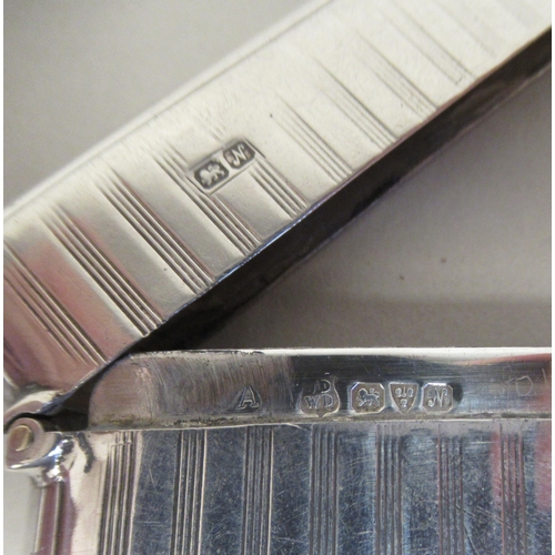 190 - A silver card case with engine turned ornament and a hinged cap  John & William Deakin ... 