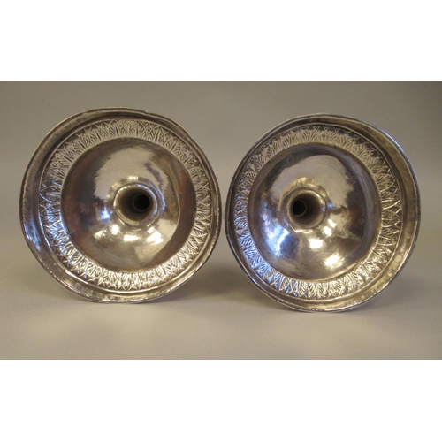 196 - A pair of 19thC Continental silver coloured metal candlesticks, the sockets with bowl shape drip-pan... 