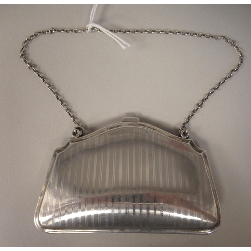 198 - An Edwardian silver purse with engine turned decoration and a chain handle, on a button clasp, enclo... 