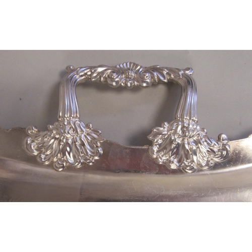 204 - A silver plated twin handled serving tray with incurved sides, a decoratively cast and engraved orna... 