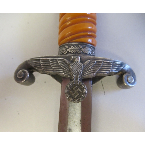 210 - A German Third Reich era army officers dagger, the spiral moulded orange phenol grip with a stiff le... 