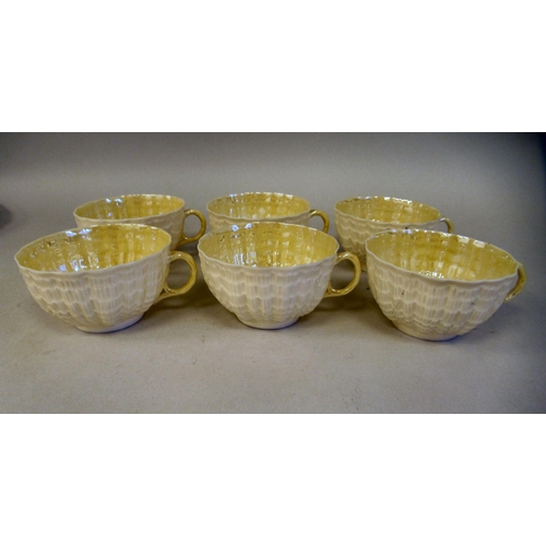 214 - A Belleek Third Period cream coloured lustre glazed, moulded porcelain teaset, comprising six cups, ... 