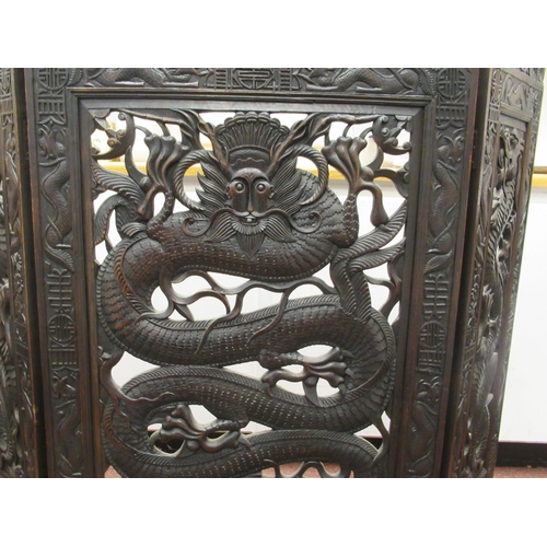 215 - A 20thC Oriental three-fold, dark stained, carved and pierced hardwood firescreen, decorated with dr... 