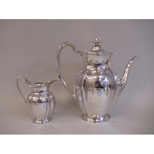 61 - An Edwardian four piece silver tea and coffee set of oval, panelled baluster form with engraved, tra... 