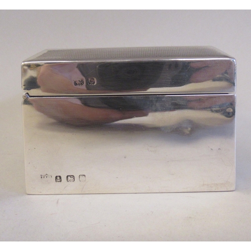 65 - A silver cigarette box with a cedar lining, straight sides and a chamfered, engine turned, hinged li... 