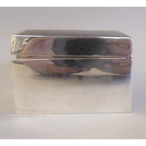 65 - A silver cigarette box with a cedar lining, straight sides and a chamfered, engine turned, hinged li... 