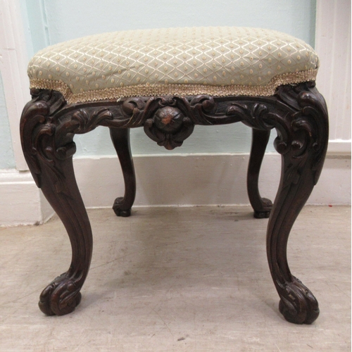 68 - A 19thC dark stained and profusely carved walnut framed stool of serpentine outline, the braided and... 