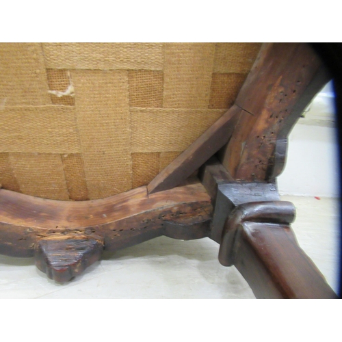 68 - A 19thC dark stained and profusely carved walnut framed stool of serpentine outline, the braided and... 