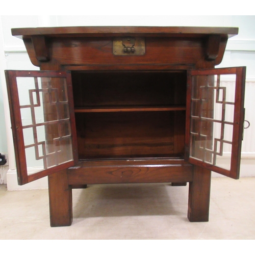 70 - A 20thC Korean elm altar design table/cabinet with a planked rising top, on brackets and an ornately... 