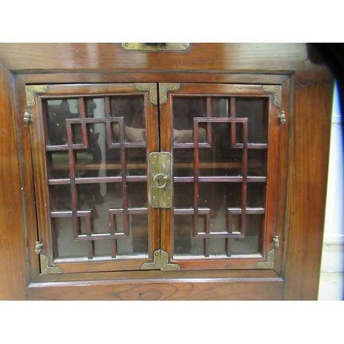 70 - A 20thC Korean elm altar design table/cabinet with a planked rising top, on brackets and an ornately... 