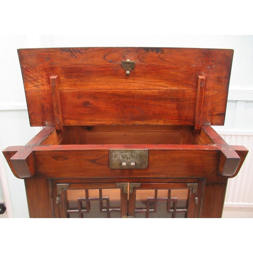 70 - A 20thC Korean elm altar design table/cabinet with a planked rising top, on brackets and an ornately... 