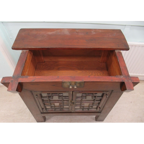 70 - A 20thC Korean elm altar design table/cabinet with a planked rising top, on brackets and an ornately... 