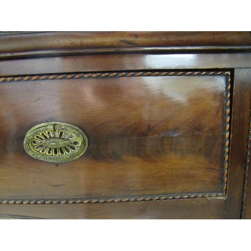 72 - An early 19thC mahogany serpentine front sideboard with carved ornament, comprising a central drawer... 