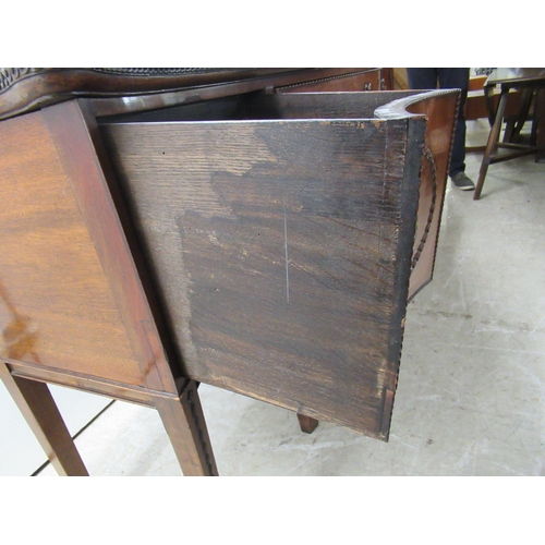 72 - An early 19thC mahogany serpentine front sideboard with carved ornament, comprising a central drawer... 