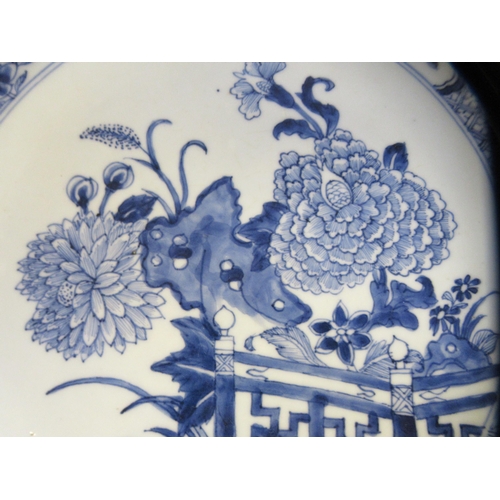 84 - A late 18thC Chinese porcelain charger, decorated in blue and white with flora in a fenced garden&nb... 