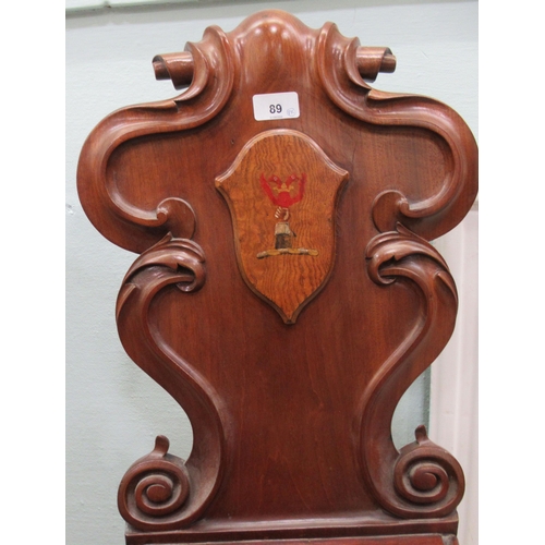 89 - A pair of mid 19thC mahogany hall chairs, the one-piece scroll carved backs with applied and painted... 