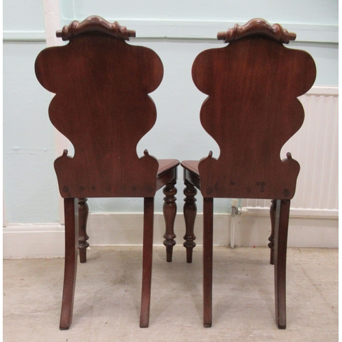 89 - A pair of mid 19thC mahogany hall chairs, the one-piece scroll carved backs with applied and painted... 