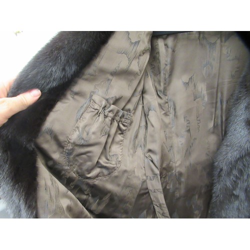 92 - A lady's SAGA knee length, lined, black mink coat with a collar and belt details to the back  approx... 