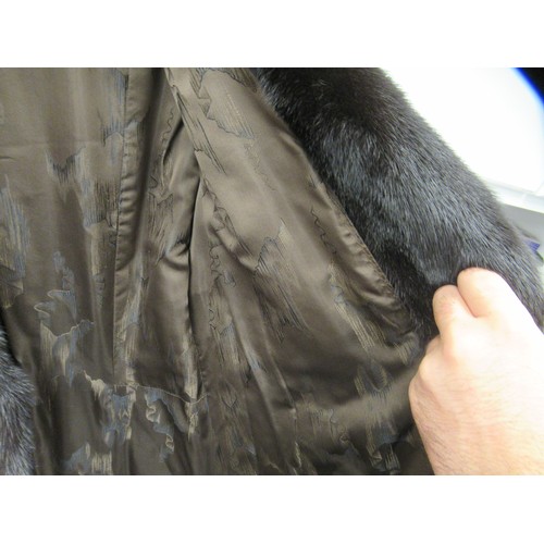 92 - A lady's SAGA knee length, lined, black mink coat with a collar and belt details to the back  approx... 