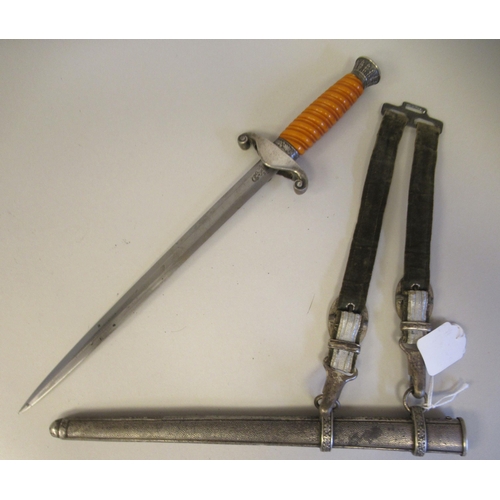 214 - A German Third Reich era army officer's dagger, the spiral moulded orange phenol grip with a stiff l... 