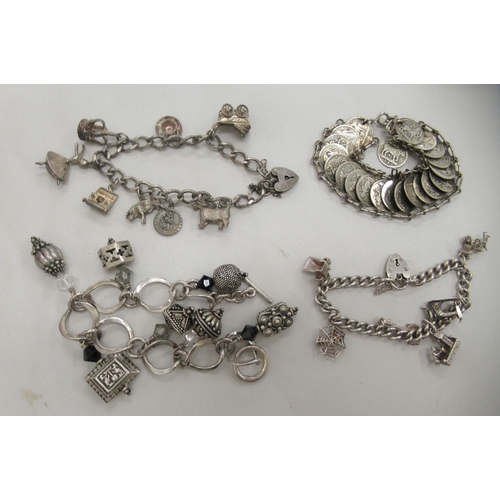 216 - Four dissimilar silver, silver coloured and white metal charm and other bracelets: to include one fa... 