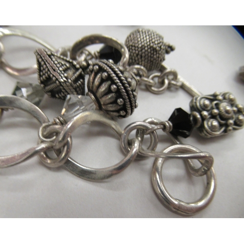 216 - Four dissimilar silver, silver coloured and white metal charm and other bracelets: to include one fa... 