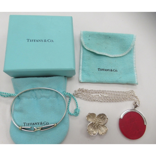 232 - Tiffany & Co silver jewellery, viz. a bi-coloured buckle type bangle; a floral brooch; and a pen... 