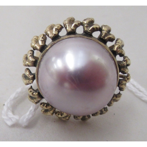 364 - A gold coloured metal, mabe set pearl dress ring 