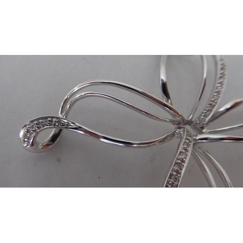 370 - An 18ct white gold and diamond set ribbon brooch 