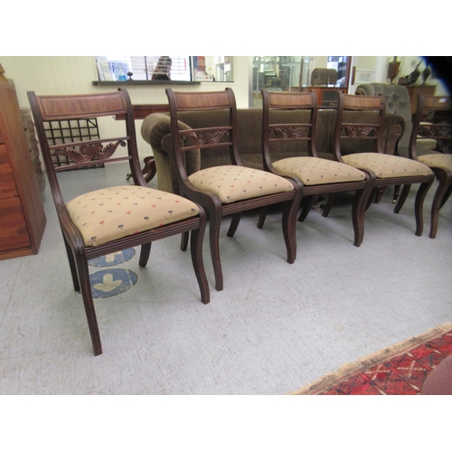 44 - A set of six Regency mahogany framed dining chairs with carved splat backs, raised on sabre legs