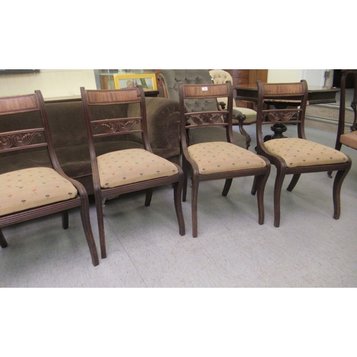 44 - A set of six Regency mahogany framed dining chairs with carved splat backs, raised on sabre legs