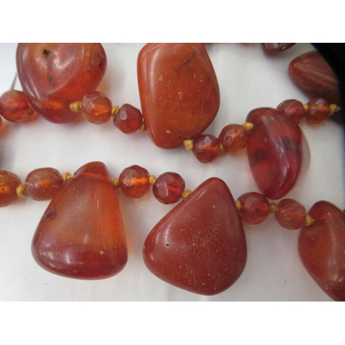 50 - A rough-cut amber coloured necklace with uniform spacers, on a ring bolt clasp