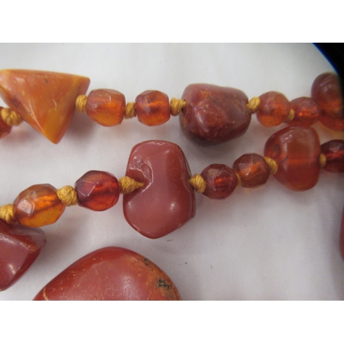 50 - A rough-cut amber coloured necklace with uniform spacers, on a ring bolt clasp