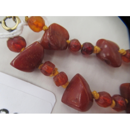 50 - A rough-cut amber coloured necklace with uniform spacers, on a ring bolt clasp