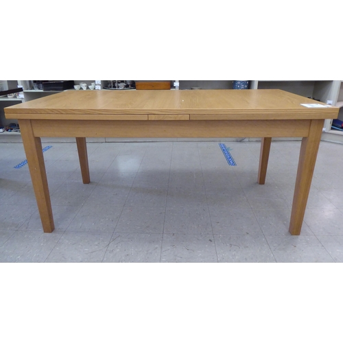 63 - A modern Danish oak finished draw leaf dining table, raised on square, tapered legs  30