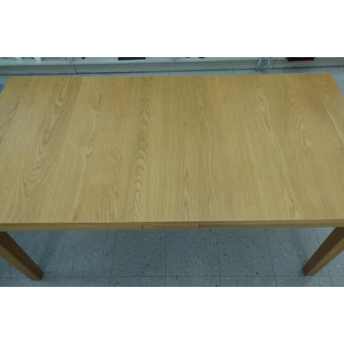 63 - A modern Danish oak finished draw leaf dining table, raised on square, tapered legs  30