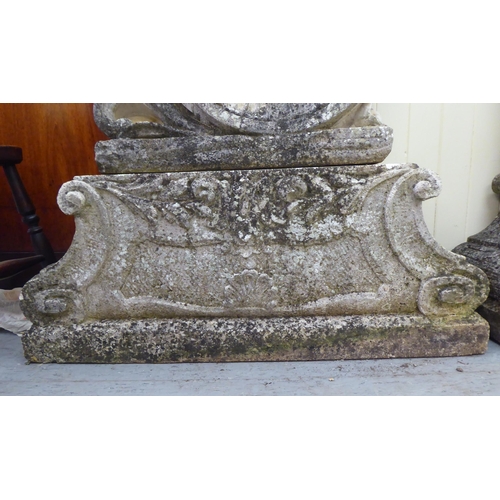 1 - A pair of composition stone, two part Four Seasons terrace ornaments, each featuring a cherubic figu... 