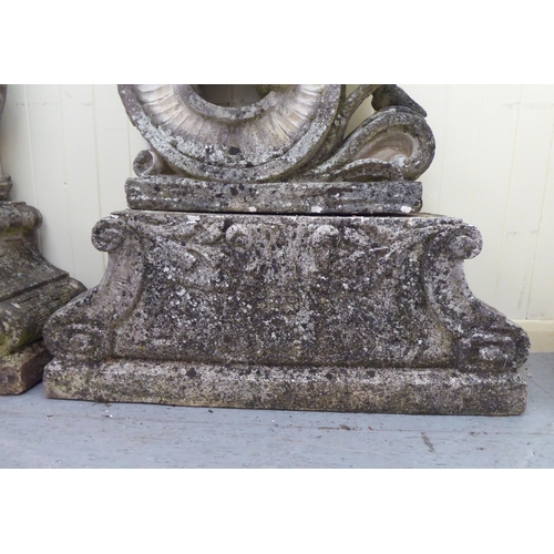 1 - A pair of composition stone, two part Four Seasons terrace ornaments, each featuring a cherubic figu... 