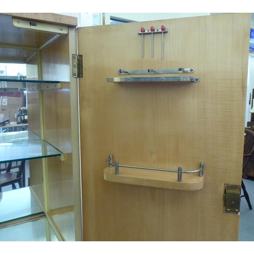 107 - A mid 20thC bleached walnut cocktail cabinet with decoratively pierced and engraved brass mounts, th... 