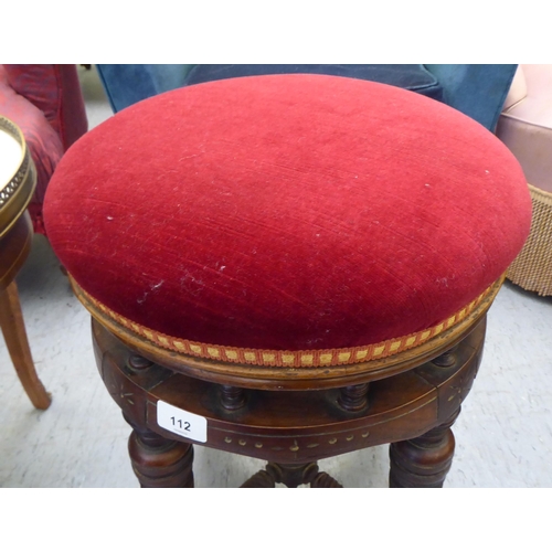 112 - A late Victorian mahogany framed music stool, raised on a multi-ring turned underframe and upholster... 